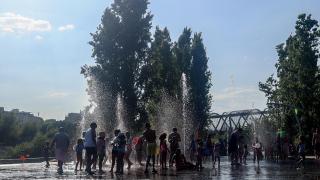 Un grupo de niños se refrescan en una fuente de Madrid Río durante una ola de calor en agosto.  Ricardo Rubio Europa Press