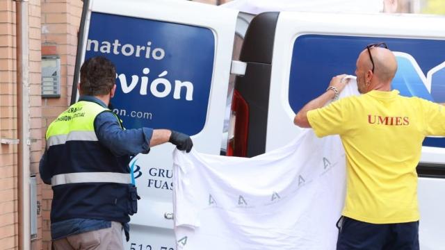 Los servicios funerarios trasladan el cadáver de la víctima del crimen machista de Pino Montano.