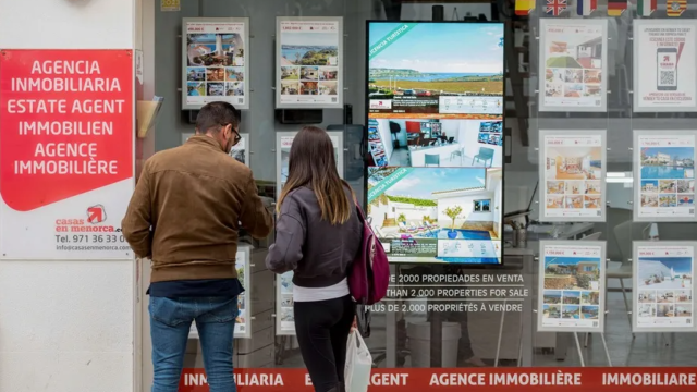 Una pareja mirando pisos en una inmobiliaria.
