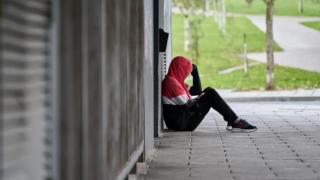 Un joven consulta su teléfono móvil en una calle de Madrid.