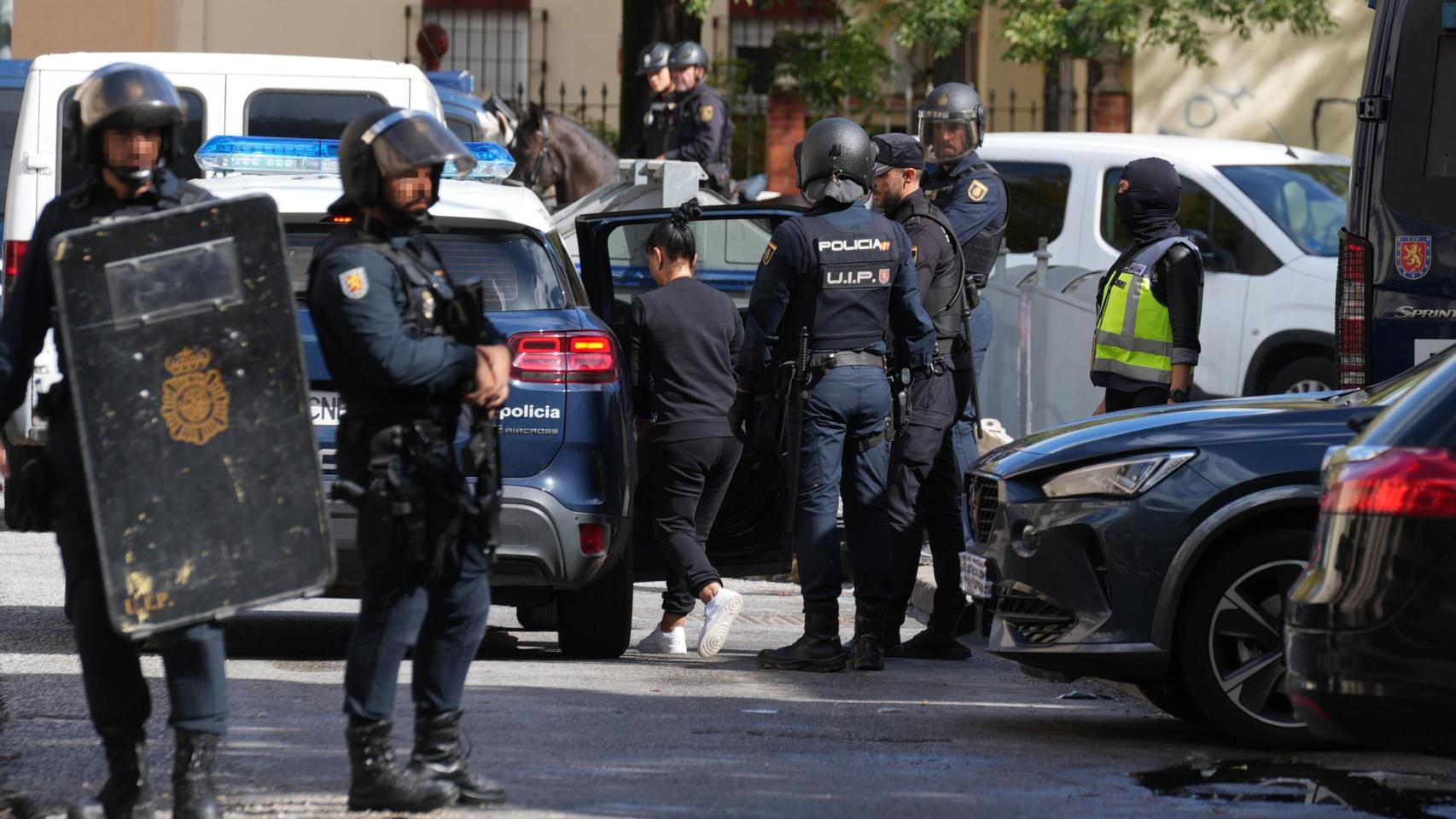 La Policía nacional introduce en el furgón a una de las detenidas.
