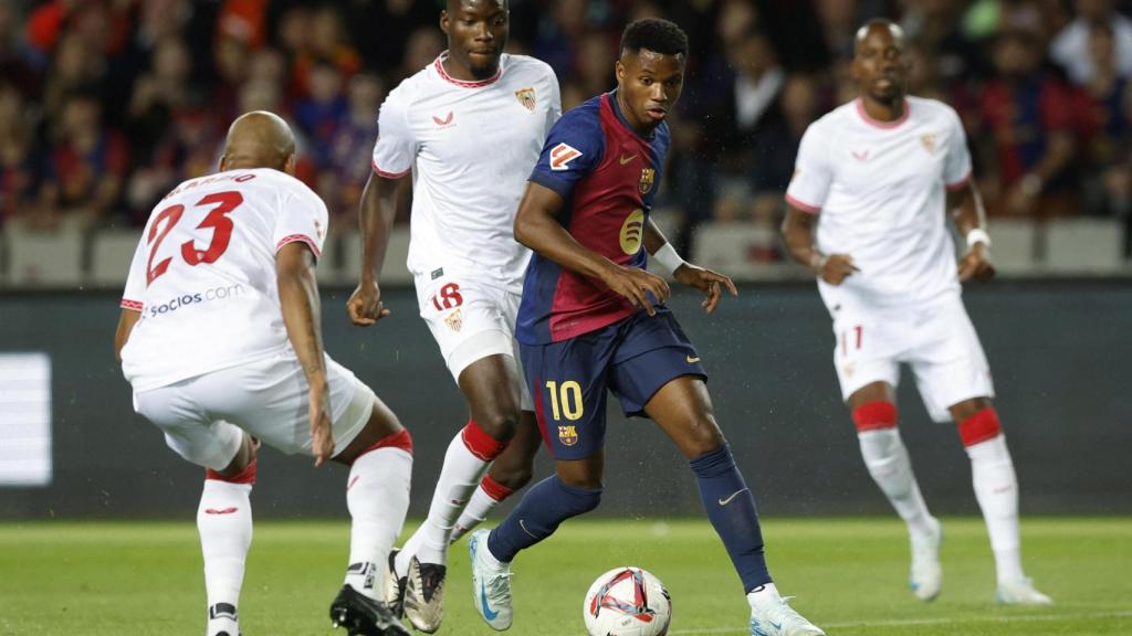 Ansu Fati se lleva el balón entre varios jugadores del Sevilla.