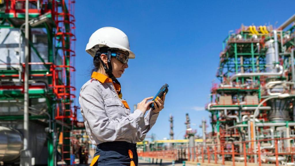 Una operaria de Repsol, usando herramientas digitales en una refinería.