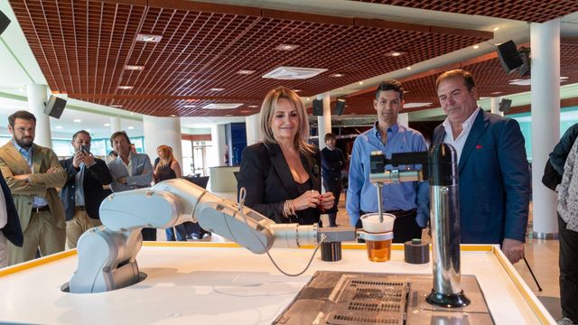 La consellera Nuria Montes, el hotelero Fede Fuster y el CEO de Bumerania Robotics, Isidro Fernández junto al brazo robotizado cervecero.,