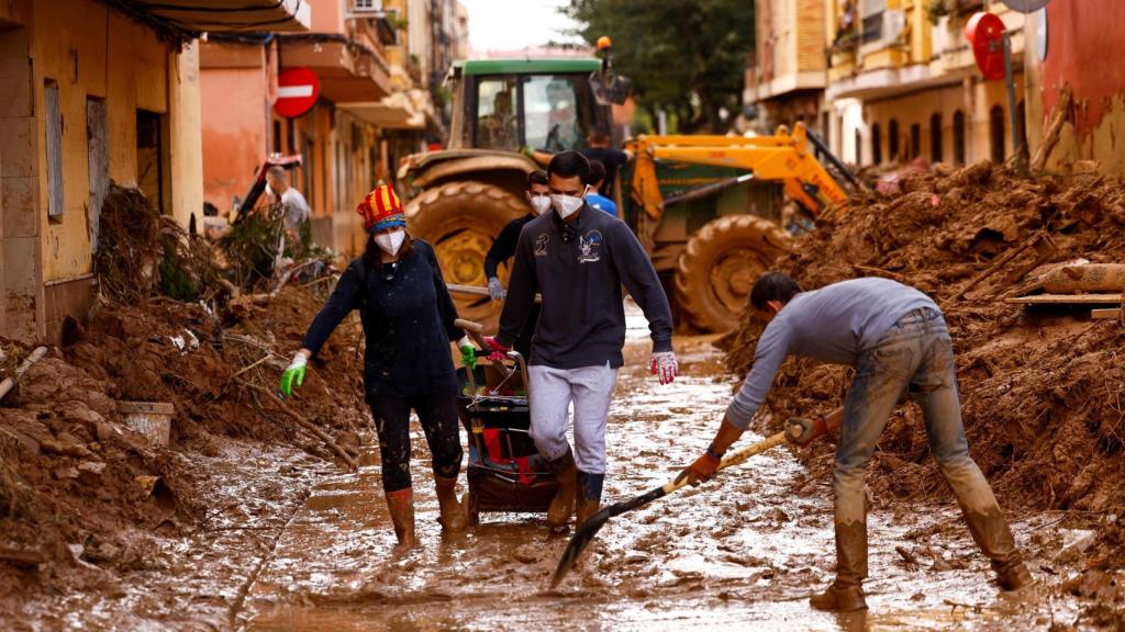 Gente limpiando el barro acumulado en las calles de Massanassa. Susana Vera Reuters Valencia