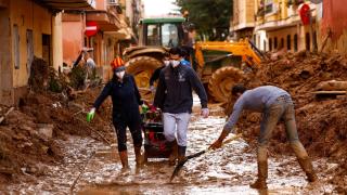 Gente limpiando el barro acumulado en las calles de Massanassa. Susana Vera Reuters Valencia