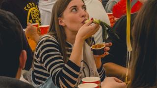 Una chica disfrutando de unos calçots.