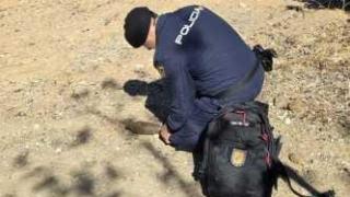 Un especialista de la Policía Nacional manipulando el artefacto explosivo.