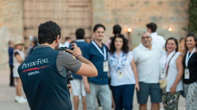 Un trabajador de Puy du Fou haciendo una fotografía a un grupo de visitantes.