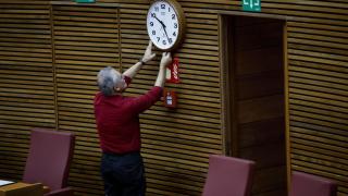 Un técnico de Les Corts ajuste de reloj del hemiciclo momentos antes del pleno de este viernes en el que el president de la Generalitat. Efe / Ana Escobar