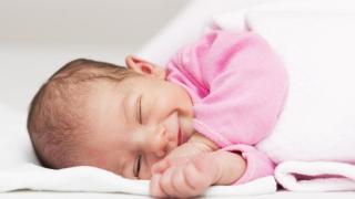 Bebé recién nacido con una sonrisa adorable.