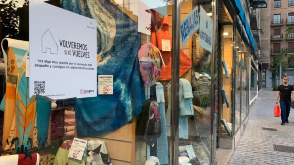 Un cartel del programa 'Volveremos' en un comercio local de Zaragoza.