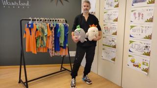 Ton Pernas, con peluches de los personajes de 'Los Wawies' ante bocetos de la serie y prendas de su colección de moda infantil Wawaland.