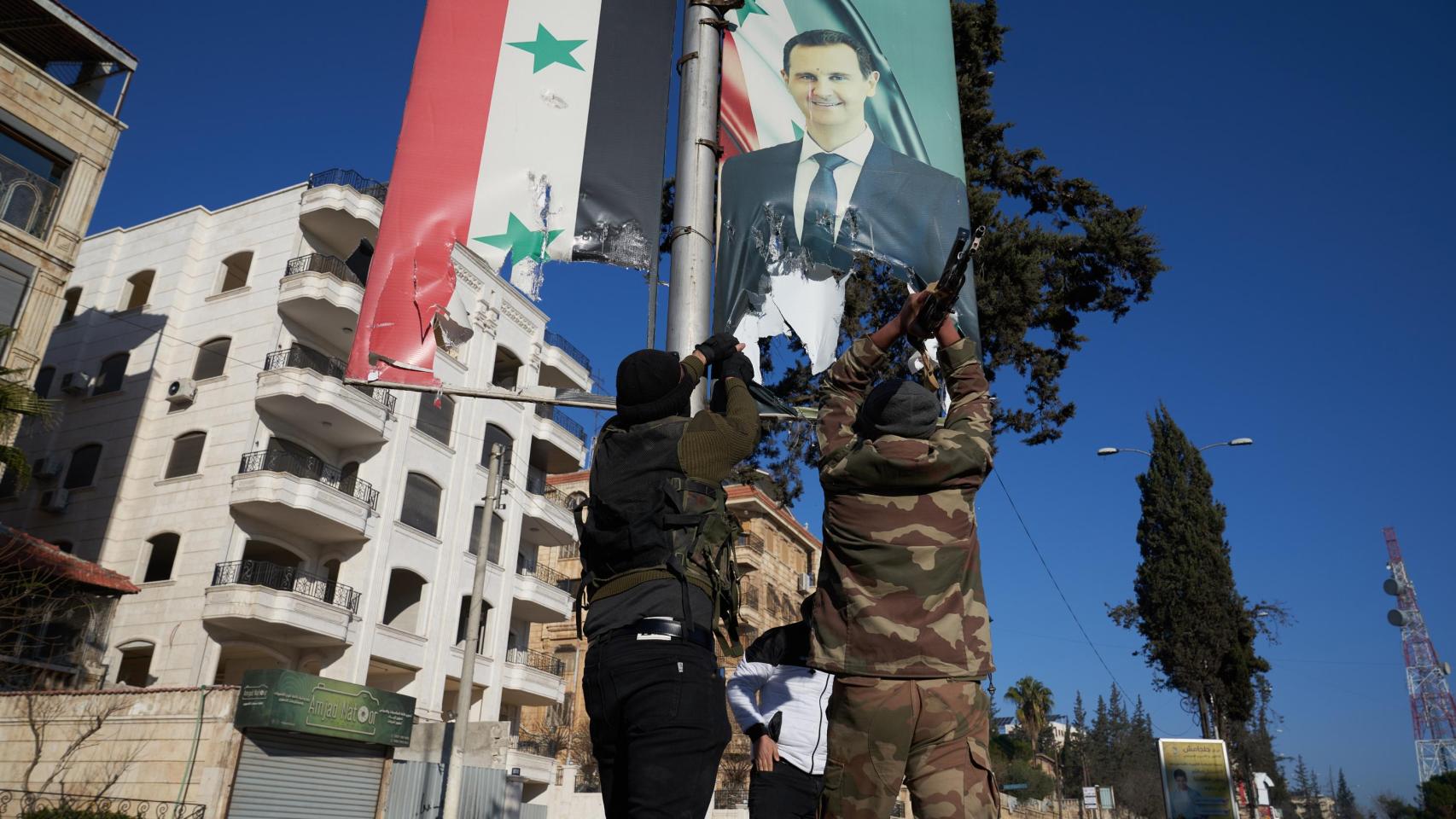 Combatientes de la oposición siria rompen un retrato del presidente sirio Bashar al-Assad en el centro de Alepo, Siria, el 30 de noviembre de 2024.