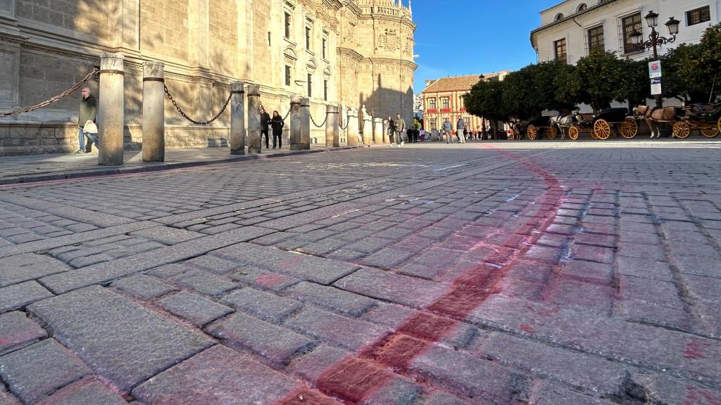 Líneas rojas pintadas en la calle por el paso de la Magna de Sevilla.
