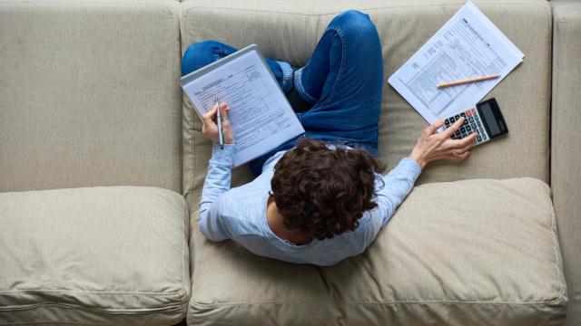 Imagen de una persona rellenando la documentación de la declaración de la Renta.