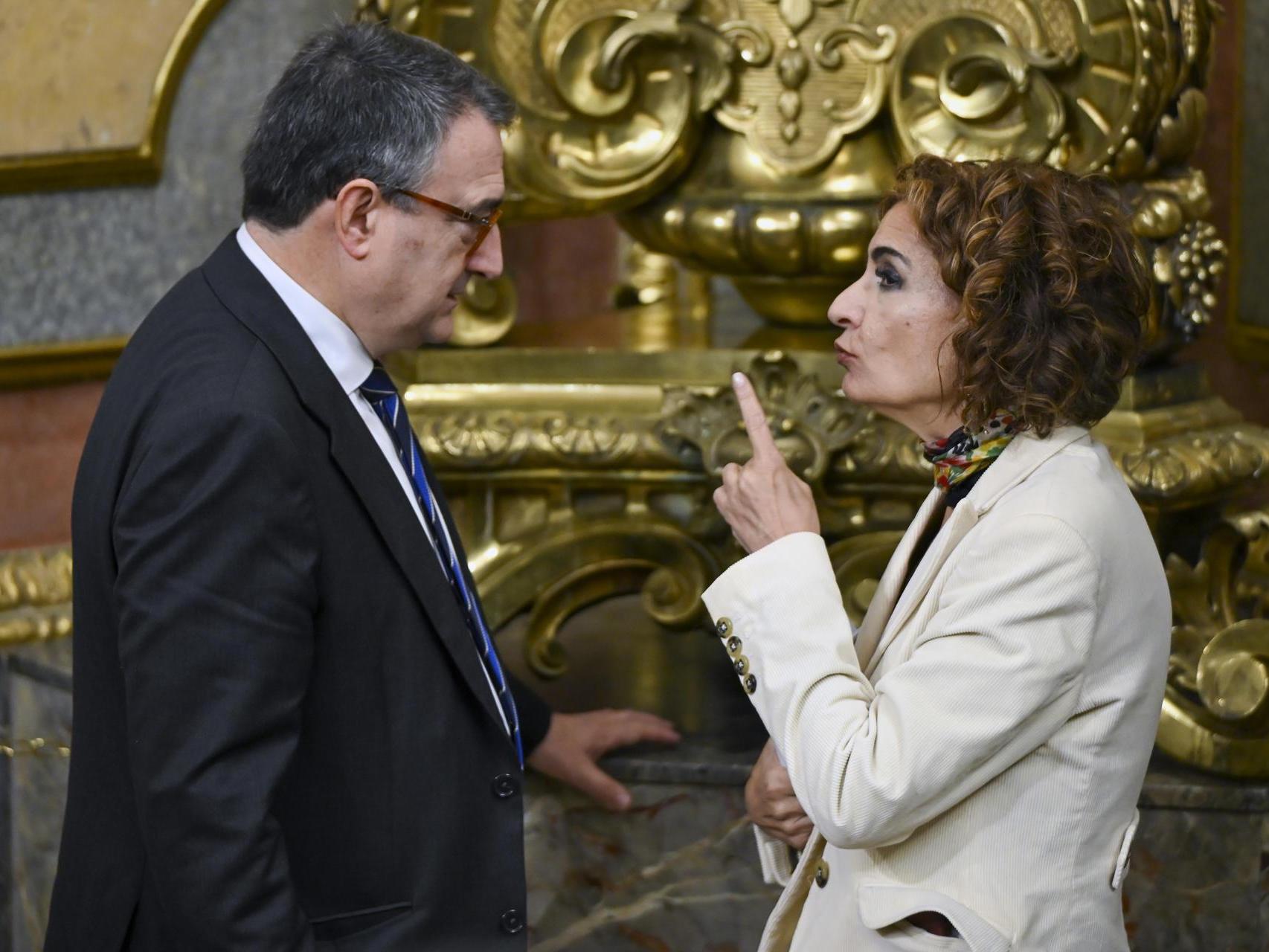 La vicepresidenta primera del Gobierno y ministra de Hacienda, María Jesús Montero, conversa con el portavoz del PNV, Aitor Esteban, este jueves en los pasillos del Congreso.