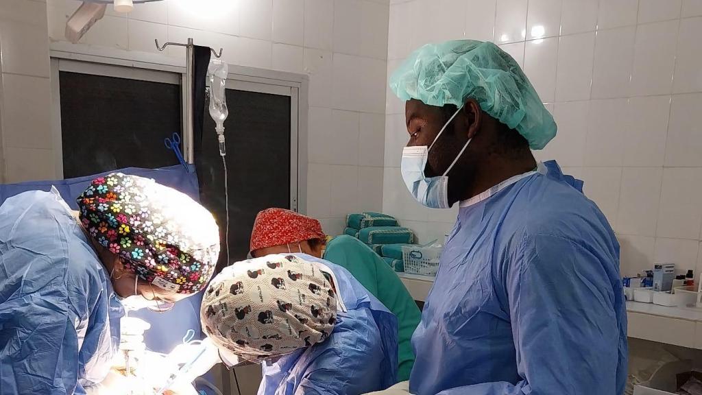 Equipo médico local y de médicas durante una cirugía.