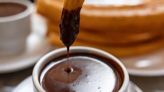 Un churro crujiente bañado en chocolate caliente.