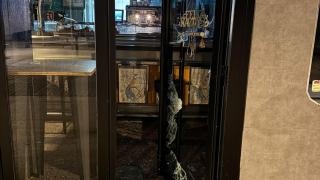 La puerta destrozada del Bar-Cafetería Nápoles, en Alcorcón.