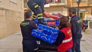 Bomberos de Málaga descargando los regalos en Valencia.