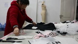 Una trabajadora de Shein confeccionando ropa.