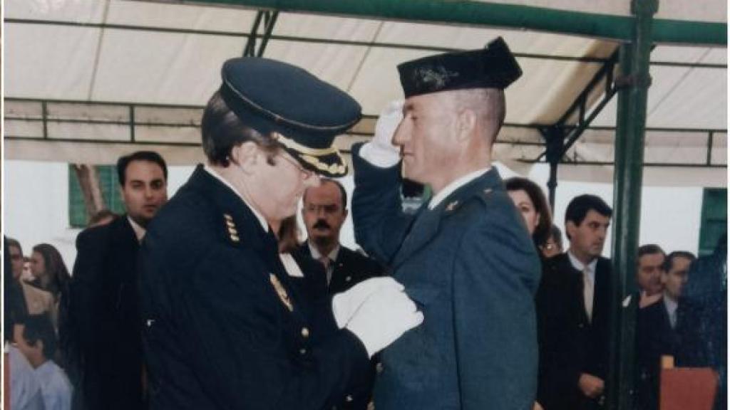 Rafael León, recibiendo una condecoración por su trabajo en la Guardia Civil, junto a una imagen del estado en el que quedó su bicicleta tras ser atropellado por una conductora en la carretera nacional 340.