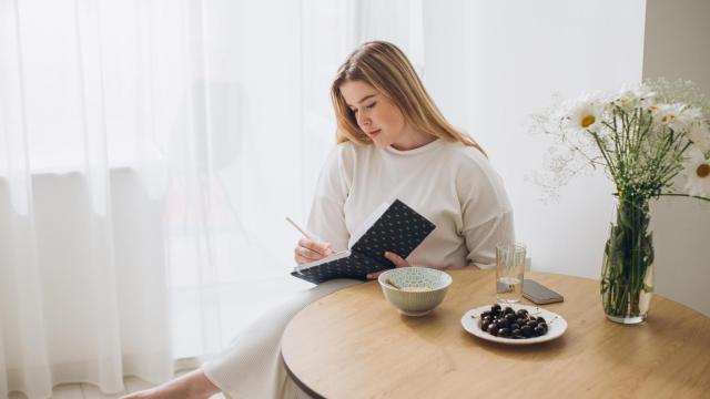 Una mujer escribe en su diario, en una imagen de Shutterstock.