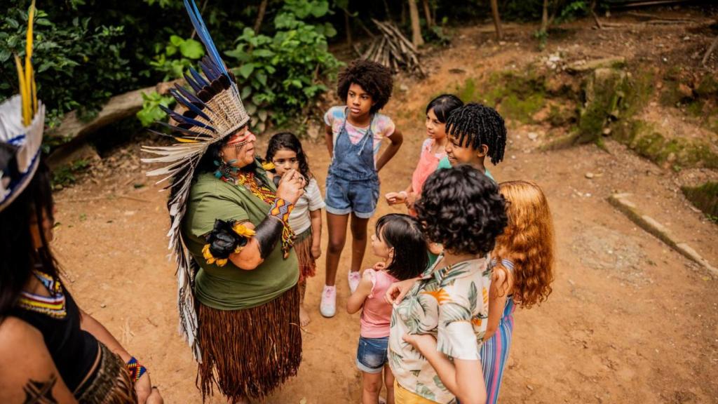 Una mujer indígena habla con niños de una escuela durante una excursión en Brasil.