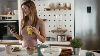 Mujer almorzando en su cocina.
