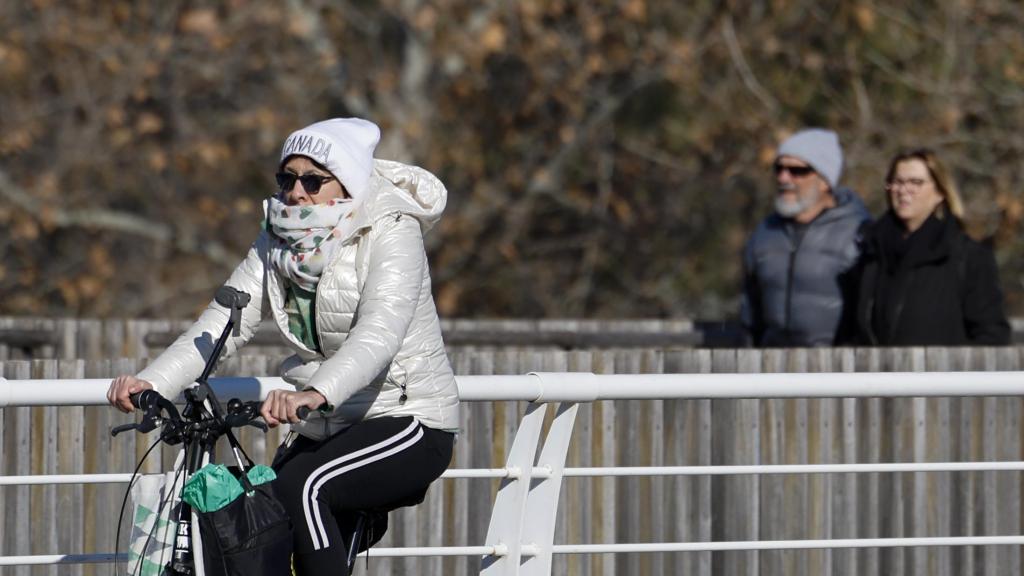 Varias personas transitan abrigadas para protegerse del frío en Valencia. Efe / Ana Escobar