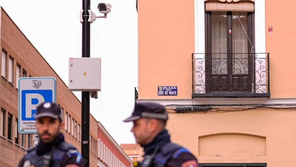 Dos agentes de la Policía Municipal junto a una de las cámaras con IA de la Plaza del Dos de Mayo.