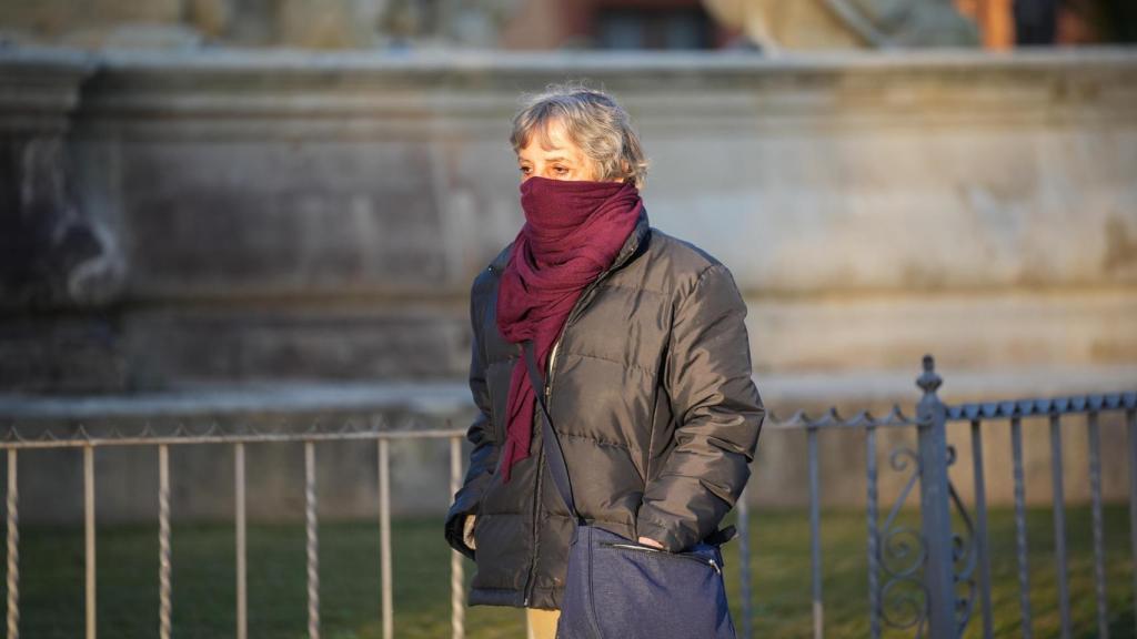 Una mujer se protege del frío en su paseo por las calles de Sevilla.