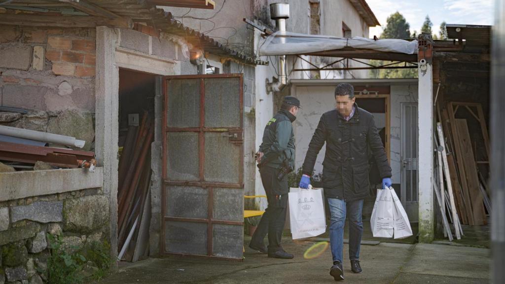 Un agente de la Guardia Civil con bolsas de pruebas de la casa donde una pareja sufrió un violento asalto, en Meis (Pontevedra), a 14 de enero de 2025