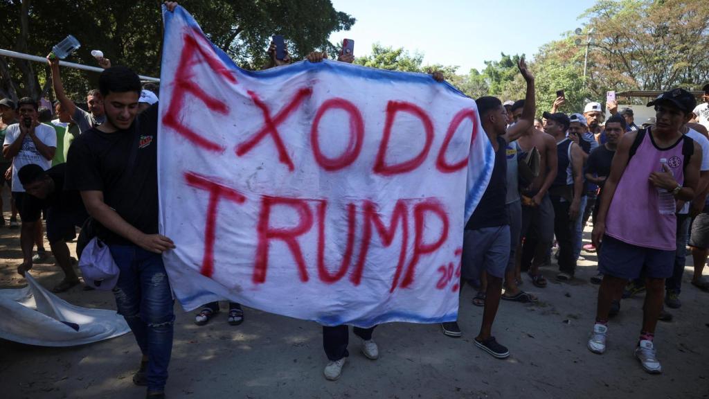 Los migrantes sostienen una pancarta que dice  Éxodo de Trump 2025, durante una marcha para protestar contra el Instituto Nacional de Migración (INM) de México.