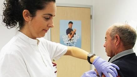 Una sanitaria vacuna  a un hombre mayor de 65.
