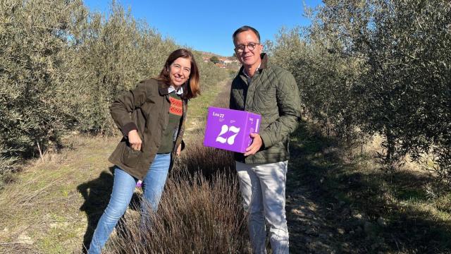 Pilar y Pedro Laguna, sujetando una caja de Loe 77, en sus campos de olivos y lavanda.