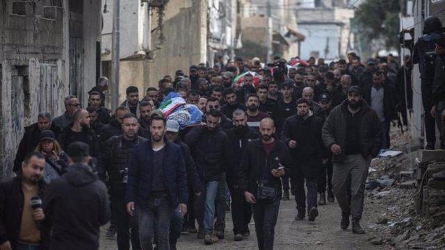 Un grupo de palestinos transporta los cuerpos de los muertos en un ataque israelí en el campamento de refugiados de Yenín.