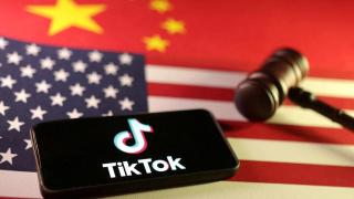 Ilustración con el logo de TikTok en un teléfono móvil, las banderas de EEUU y China y el mazo de un juez.