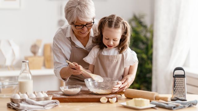 Una abuela cocina con su nieta