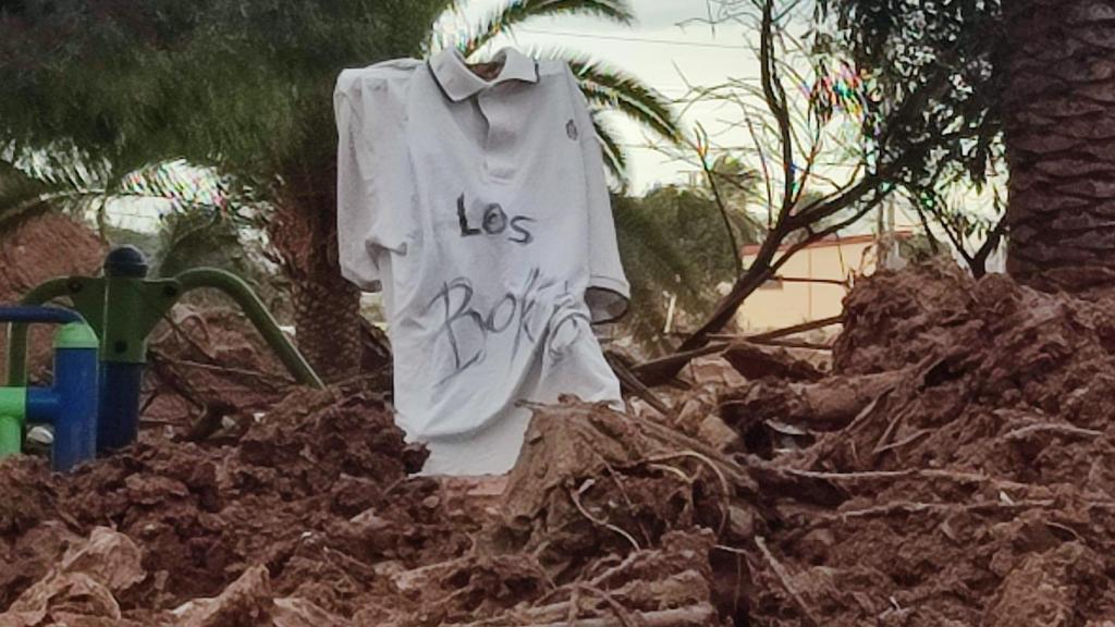 El polo del antiguo uniforme colgado de una estaca en Paiporta.