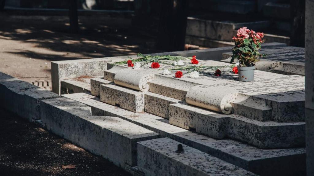 Flores en una lápida del cementerio Sacramental de San Isidro de Madrid.