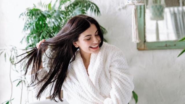 Mujer en albornoz con el cabello húmedo.