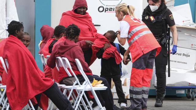 Un grupo de personas migrantes, entre ellos menores, es atendido por la Cruz Roja este martes en el puerto de Los Cristianos.