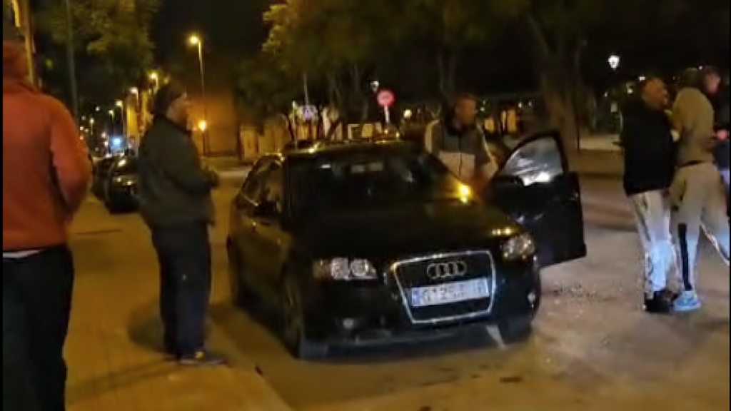 El conductor detenido, antes de subirse al Audi, para atropellar al ciudadano africano al que sujeta un ciudadano marroquí, para evitar la pelea.