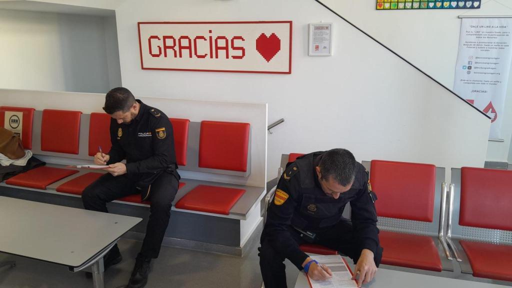 Dos agentes de la policía rellenando el formulario para donar sangre.