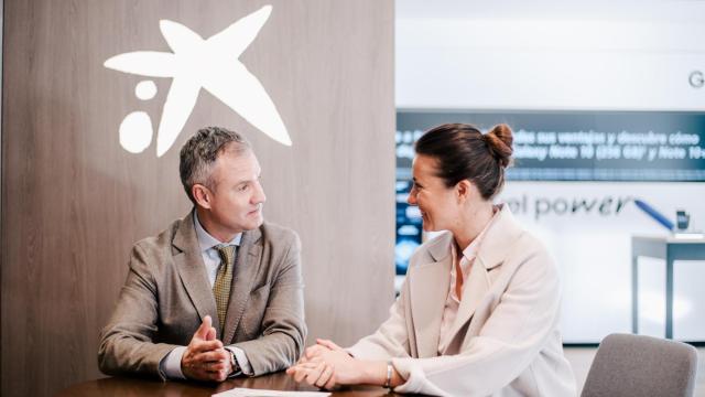 Dos personas en una oficina de CaixaBank.