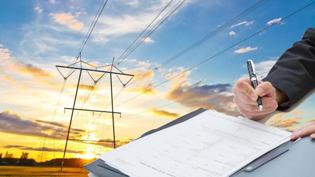 Fotomontaje de una firma de PPA (power purchase agreement) o contrato bilateral a largo plazo de energía con el fondo de una red de alta tensión eléctrica.