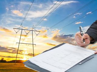 Fotomontaje de una firma de PPA (power purchase agreement) o contrato bilateral a largo plazo de energía con el fondo de una red de alta tensión eléctrica.