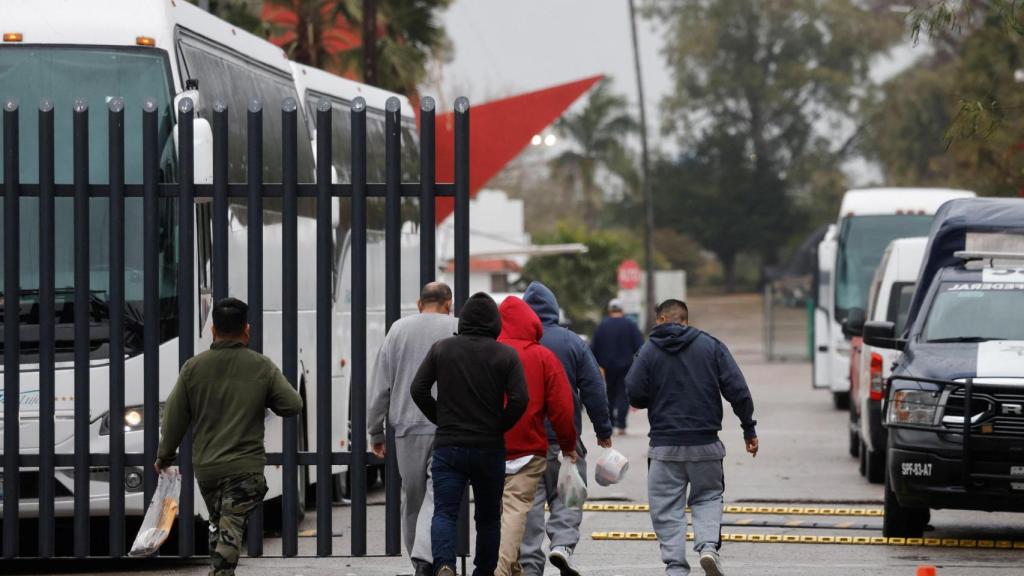 Migrantes deportados por EEEUU se dirigen a un autobús del Instituto Nacional de Migración (INM) de México, en la localidad de Matamoros.